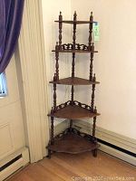 Full view of the Victorian wooden whatnot corner shelves with four tiers, turned spindles, and finial tops. Shows overall shape and condition.