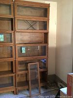 Full view of five-section wooden barrister bookcase stack; one glass door leaning against base
