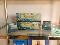 Four Piper Heidsieck chewing tobacco tins displayed on a shelf, showing front and side views with visible branding and vintage design.