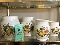 Four white storage crocks on shelf with appetizing food and drink graphic designs, gently used condition.