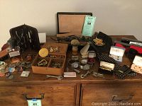 Overview of men's accessories on dresser, including jewelry box, watches, grooming tools and pins