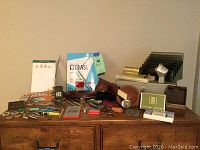 Wide photo of entire assortment of office supplies and accessories on wooden surface, several items grouped together.