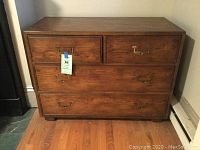 Front view of dresser showing four drawers and brass bail handles.