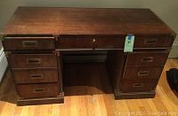 Front view of desk showing all drawers and brass hardware