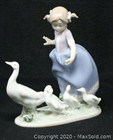 Front view showing the girl and four ducks on porcelain base with glazed finish.
