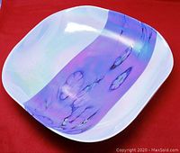 Front view of square-shaped opalescent Murano glass bowl with purple floral band on white background.