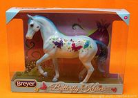 Front view of the Breyer Butterfly Kisses horse in original packaging, showing hand painted butterflies and glossy finish on the blue and white stallion.