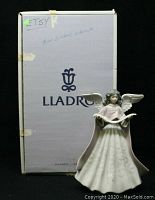 Front view of the Lladro angel figurine with original box behind it.