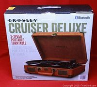 Box showing Crosley Cruiser Deluxe 3-speed portable turntable with Bluetooth logo.