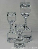 Three crystal clear glass Art Deco style candle holders on white background, viewed from front.