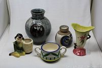 Overview of the lot showing five pottery items including vases, a planter, and bowls.