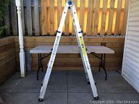 Mastercraft aluminum ladder in an open A-frame position showing its height and structure in an outdoor setting.
