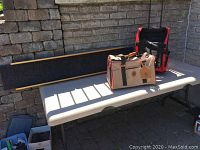 Photo showing entire lot on table with pet ramp and two pet travel bags, one tan and the other red and black.