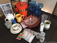 Photo of assorted cups, vases, bowls including Wedgwood Peter Rabbit dishware and glassware collection