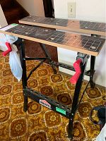 Front view of the black metal and wooden workbench showing red clamp handles and Jobmate label.