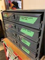 Front view of gray metal cabinet with four labeled drawers