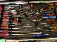 Overview of multiple assorted screwdrivers including Craftsman brand in black tool tray.