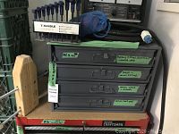 Front of gray metal parts cabinet showing four drawers with labels
