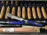 Multiple boxwood-handled Marples chisels and additional carving tools arranged in molded plastic case