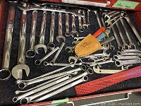 Top-down view of assorted wrenches in red drawer