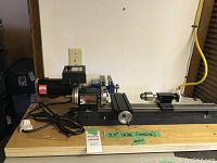 Front view of Sherline lathe on wooden base showing motor, headstock, and lathe bed