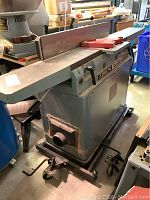 Full view of Delta DJ-20 jointer showing infeed and outfeed tables and overall condition