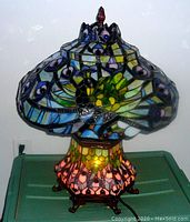 Front view with base light on, shade off shows illuminated base mosaic and metal frame