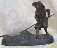 Full view of signed O.Medina Art Nouveau table lamp showing figure, base, and flame glass shade.