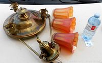 Disassembled lamp parts including ceiling cap, pan, suspension rods, and three glass shades