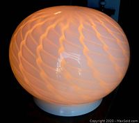 Front view of lamp illuminated showing swirling opalescent pattern