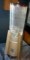 Full view of Waring blender showing gold-tone metal modernist Art Deco base, ridged glass container, wooden top knob