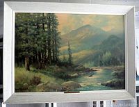 Frontal image showing the full wood framed art print featuring a river and mountain landscape.