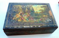 Top view of wooden box showing printed scene with wear and cracking