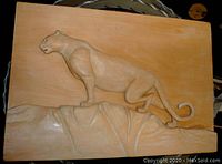 Front view of the carved wooden wall hanging depicting a panther on rocky ledge.