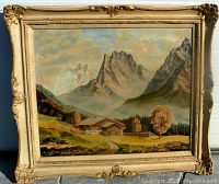 Frontal view of the framed oil painting showing the alpine mountain scene with chalet and trees under a cloudy sky, highlighting the ornate wooden frame.