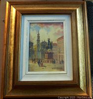 Framed oil painting showing a historical piazza with a statue on a horse and classical buildings around. The frame is a gilt wood.