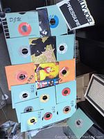 Various 45 RPM vinyl records arranged on a chair with colorful and plain paper sleeves, some with artist covers including David Bowie and others.