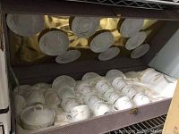 Full view of the unopened case displaying tea cups, saucers, creamer, and sugar bowl on satin lining.