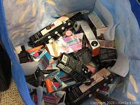 Top view of a blue bag filled with boxed nail polish and beauty products.