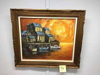 Front view of framed oil painting featuring houses, boats, and a large orange sun