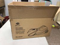 Closed cardboard box with Mlmlant brand and labeled MLA-SC541 steam cleaner model printed on side, image of steamer included.
