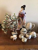 17-inch Japanese doll in fabric kimono displayed with tea set, glass floral trees, and elephant candle holder