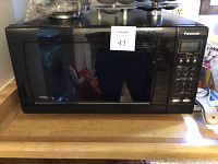 Closed view of the Panasonic microwave showing the black front, keypad, and digital display.