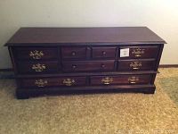Closed front view of the Huppe cedar chest showing multiple drawers with brass hardware and wooden knobs.