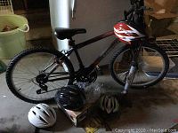 Overall view of the Supercycle SC1800 bike with helmets and accessories arranged on the floor beside it.