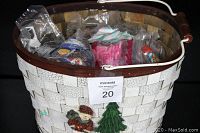 Photo showing the white crackled woven deluxe decorated Christmas basket with wooden handle filled with bagged toys.
