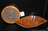 Photo showing front view of the Olympic Games bronze wall clock and the Hawaiian carved wooden bowl placed adjacent to each other.