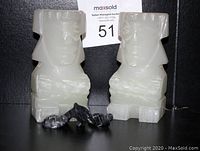 Pair of white onyx Aztec Mayan figurine bookends with black onyx turtle and whale figurines in front.
