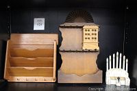 Four vintage wooden pieces on shelving: teak wall organizer on left, wooden wall spoon display in center, articulating mini cabinet attached to spoon display, and pipe organ on right.