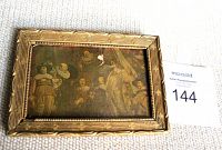 Framed print artwork showing several period figures, small tear in print visible near top center, gold decorative frame.